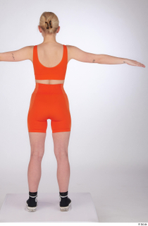 Unaisa dressed orange bike shorts orange sports bra standing t-pose…